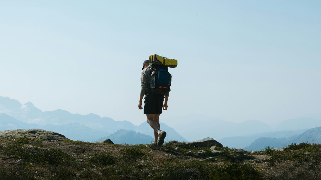 Person rucking with a loaded backpack on a mountain trail