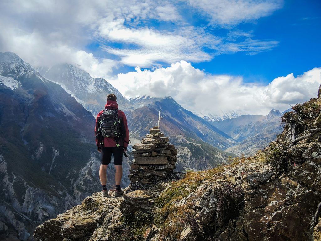 Hiker standing tall with a backpack on a mountain trail